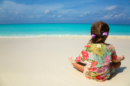 Child meditating on the beach