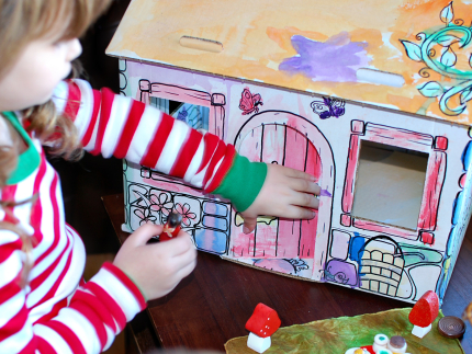 Playing with a cardboard cottage