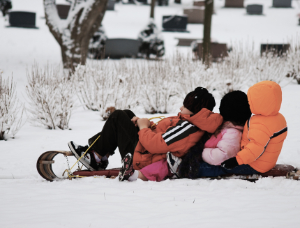 3 Kids sledding  on a Tobaggan